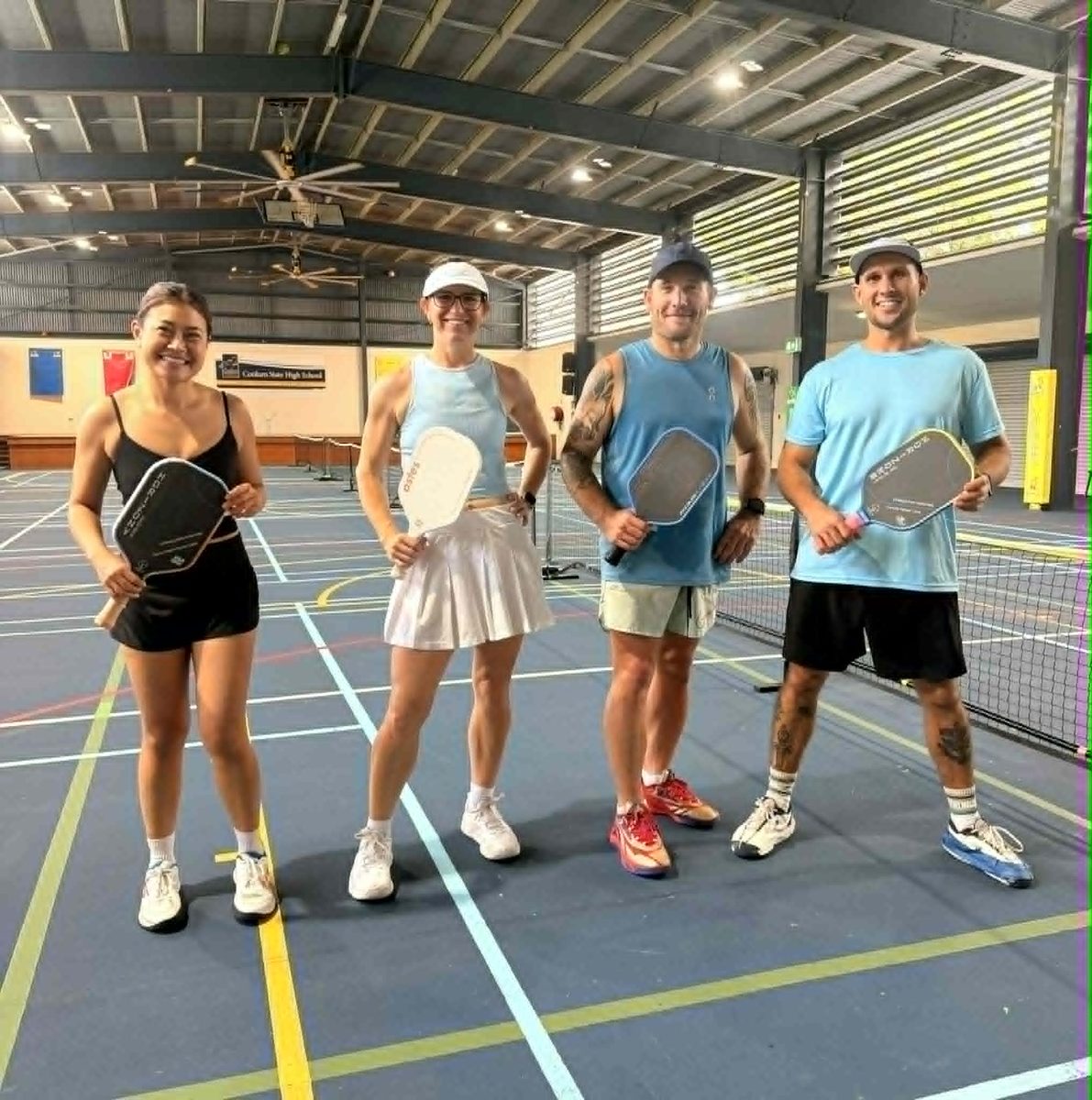 Four players on court with paddles